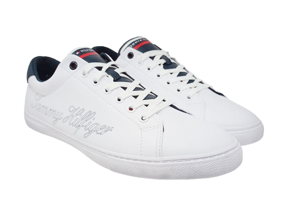 Tenis Tommy Hilfiger color blanco con detalles en azul marino y firma delineada en el costado.