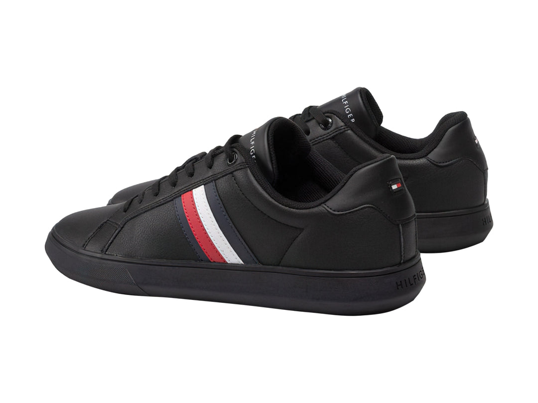 Tenis negros de cuero Tommy Hilfiger con franjas laterales blancas y rojas y suela negra.