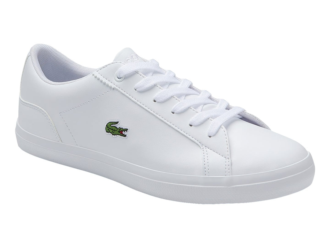 Tenis Lacoste blancos de cuero para niño con suela plana y logotipo del cocodrilo en el lateral.