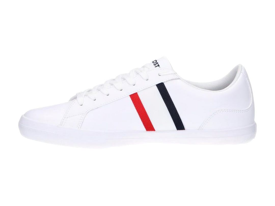 Tenis blancos Lacoste de corte bajo con franjas azul marino y rojo en el lateral y logotipo del cocodrilo.