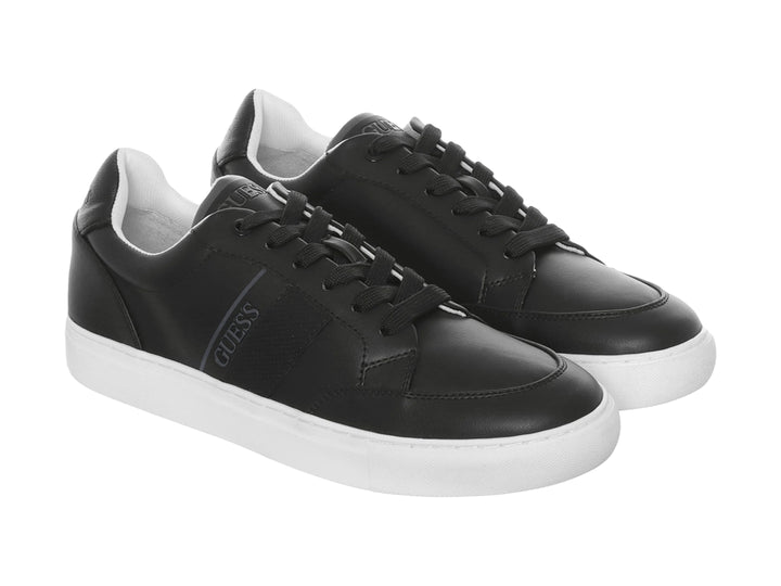 Tenis Guess color negro con suela blanca y diseño casual de corte bajo.