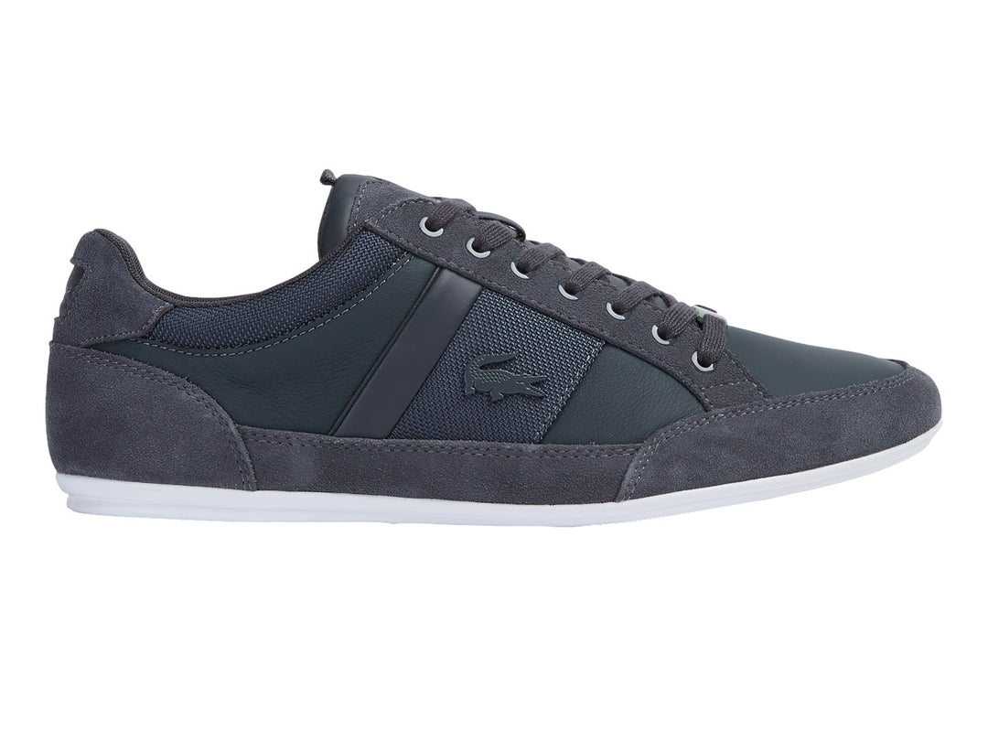 Tenis Lacoste color gris con suela blanca, detalles en gamuza y tela.