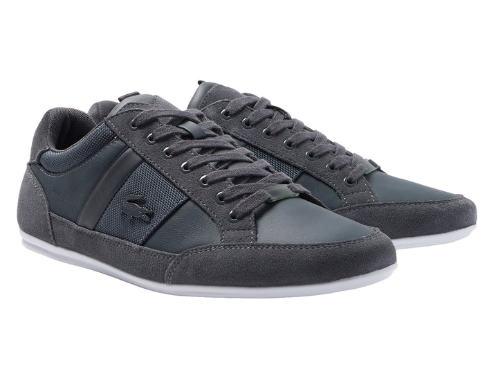 Tenis Lacoste color gris con suela blanca, detalles en gamuza y tela.