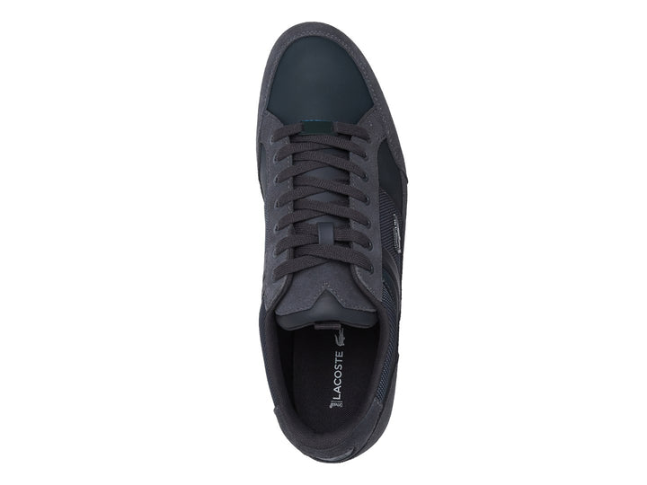 Tenis Lacoste color gris con suela blanca, detalles en gamuza y tela.