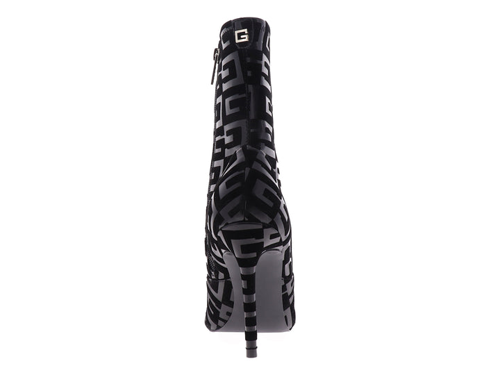 Botín negro de tacón alto y punta afilada con estampado de logotipos Guess en acabado brillante.