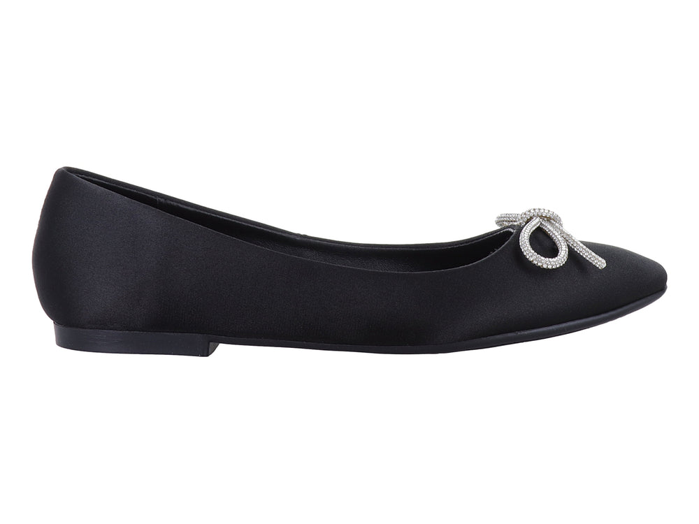 Zapato plano negro de material brillante con un moño decorativo de pedrería plateada en la punta.