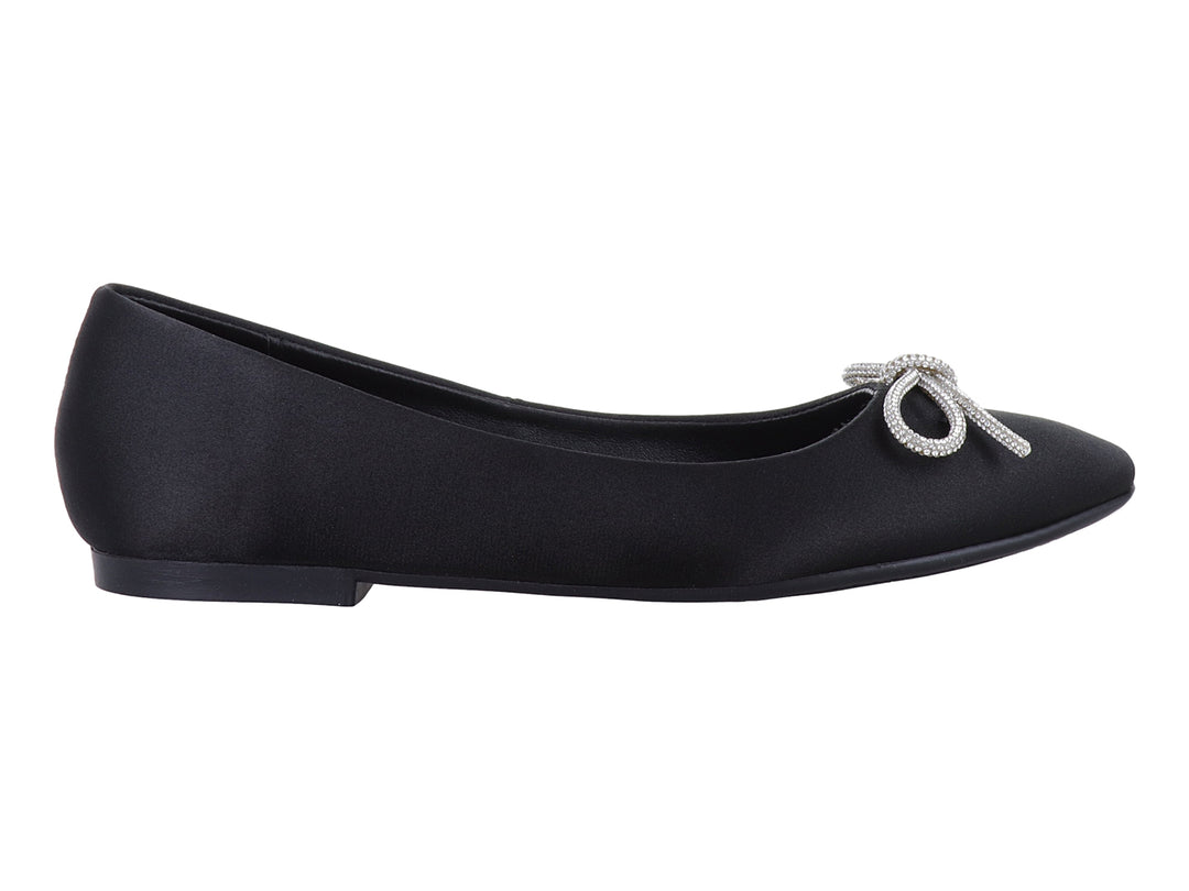 Zapato plano negro de material brillante con un moño decorativo de pedrería plateada en la punta.