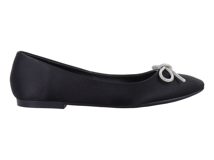 Zapato plano negro de material brillante con un moño decorativo de pedrería plateada en la punta.