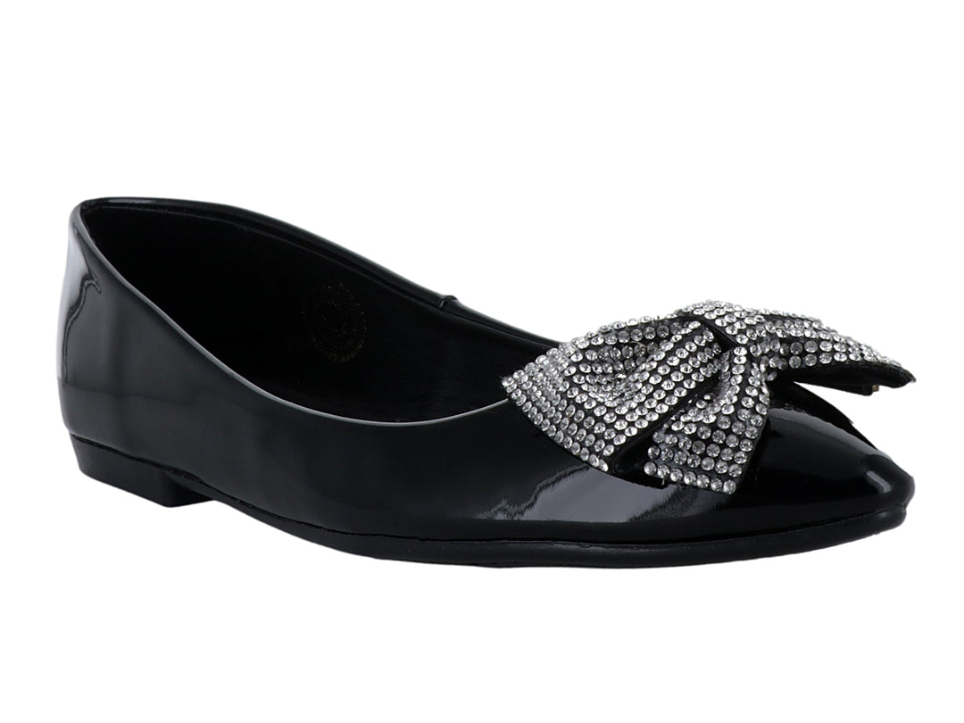 Zapato plano de charol negro con un moño decorativo de brillantes en la parte frontal.