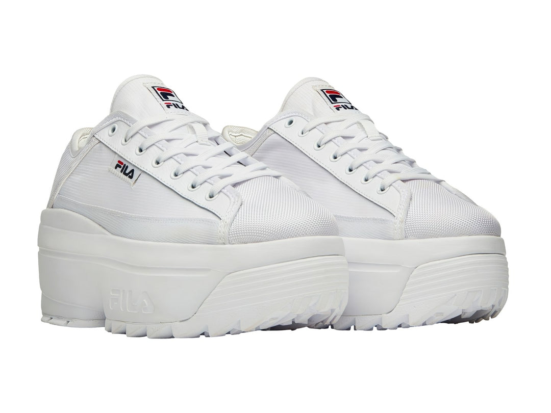 Tenis FILA Zora Trail Low color blanco con suela de plataforma gruesa y dentada.