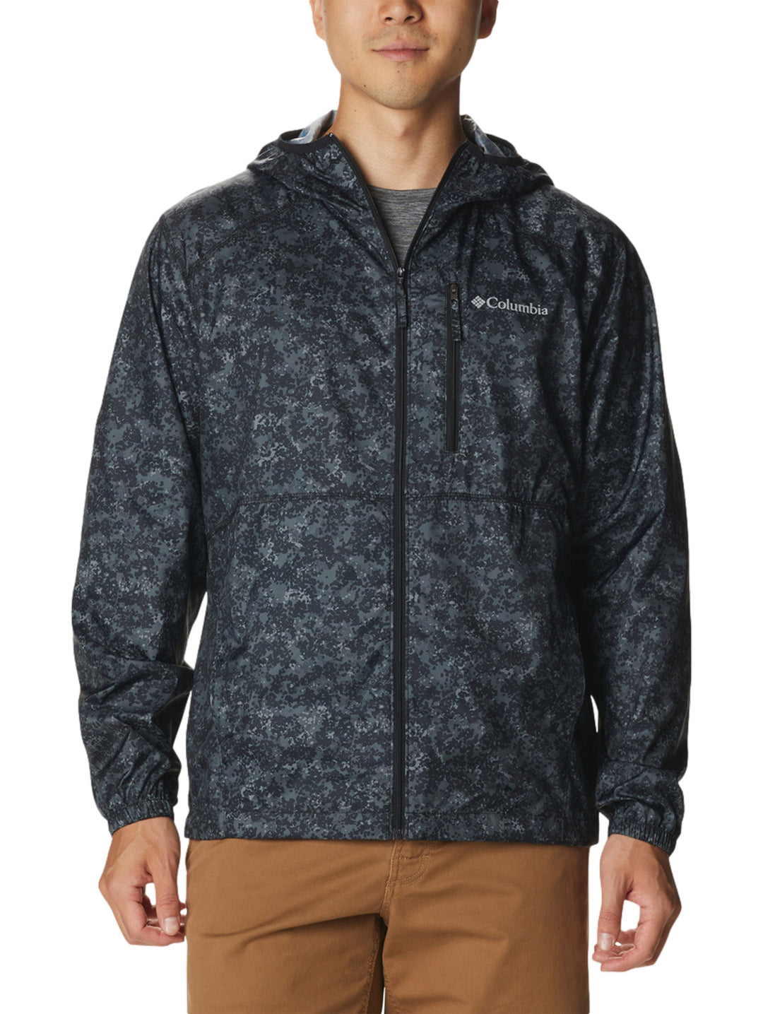 Rompevientos Columbia negro con estampado de puntos grises, capucha y cierre frontal.