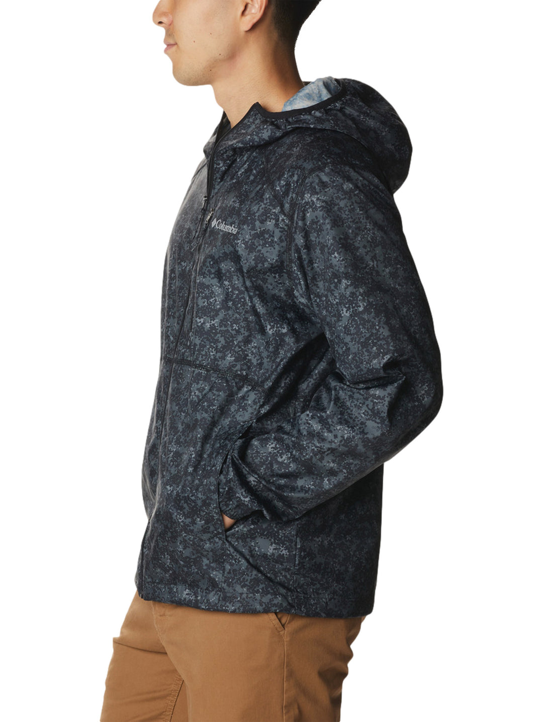 Rompevientos Columbia negro con estampado de puntos grises, capucha y cierre frontal.