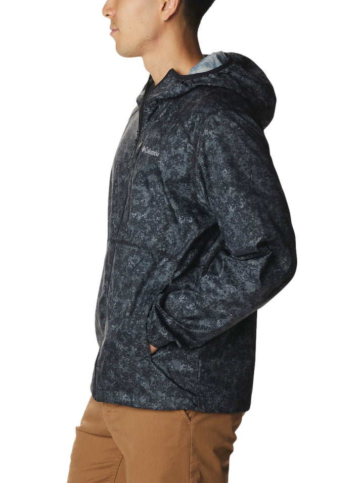 Rompevientos Columbia negro con estampado de puntos grises, capucha y cierre frontal.