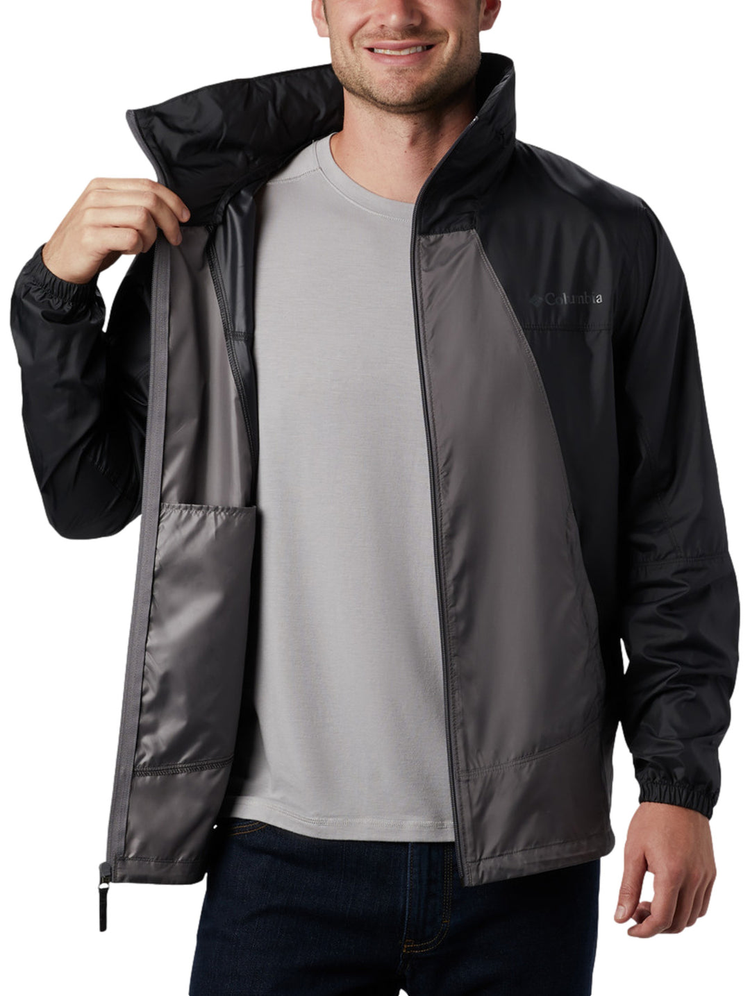 Chaqueta rompevientos Columbia bicolor en gris y negro con capucha y cierre frontal.