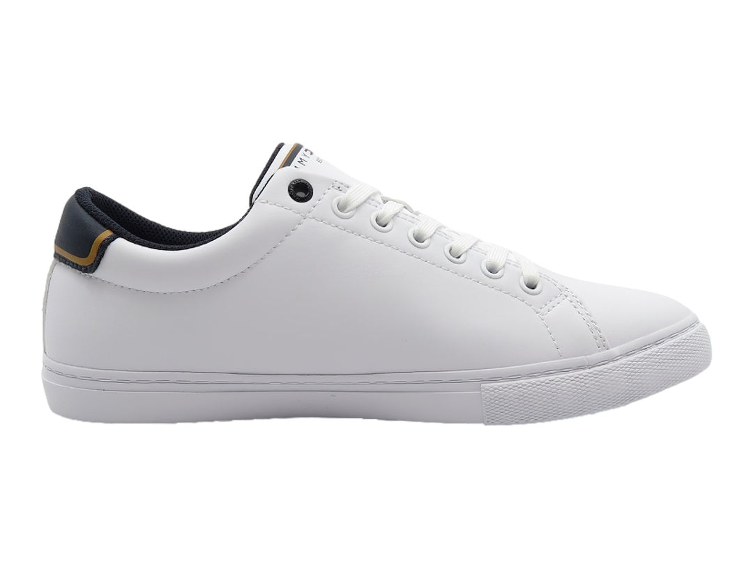 Tenis blancos de corte bajo con detalles en azul marino y dorado en el talón y la lengüeta.
