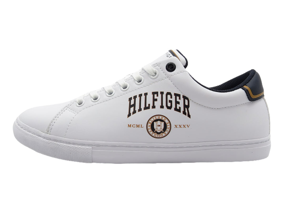 Tenis blancos de corte bajo con detalles en azul marino y dorado en el talón y la lengüeta.