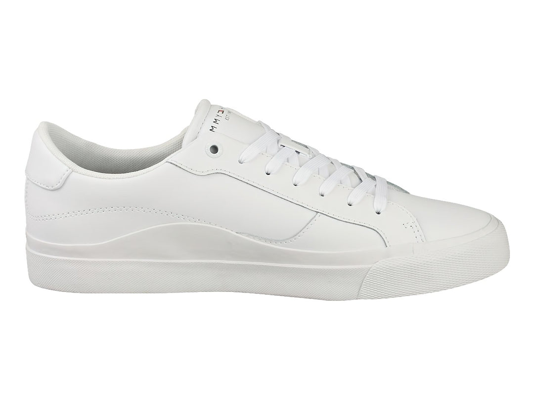 Tenis blancos de cuero Tommy Hilfiger con suela plana y cordones blancos.
