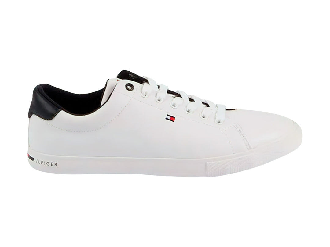 Tenis blancos Tommy Hilfiger de corte bajo con detalle negro en el talón y suela blanca.