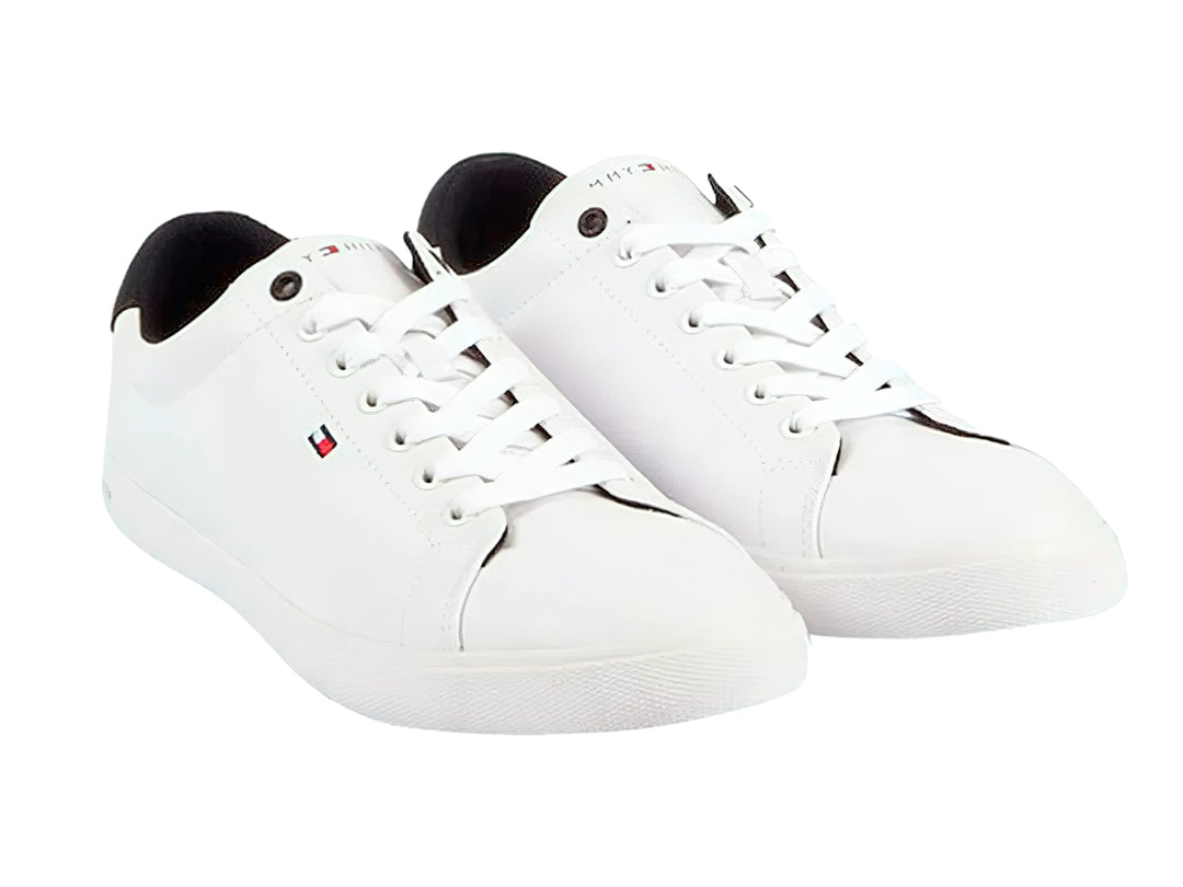 Tenis blancos Tommy Hilfiger de corte bajo con detalle negro en el talón y suela blanca.