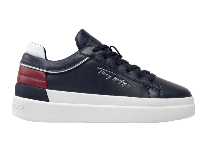Tenis de cuero color azul marino con suela blanca y detalle rojo en el talón.