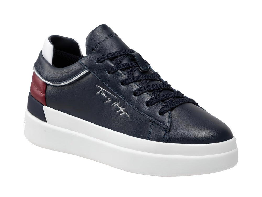 Tenis de cuero color azul marino con suela blanca y detalle rojo en el talón.