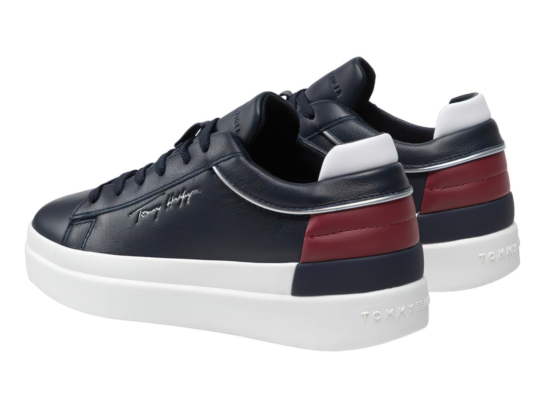Tenis de cuero color azul marino con suela blanca y detalle rojo en el talón.