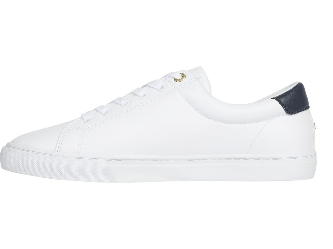 Tenis blancos de mujer marca Tommy Hilfiger con estampado de escudo en el lateral y detalle azul marino en el talón.
