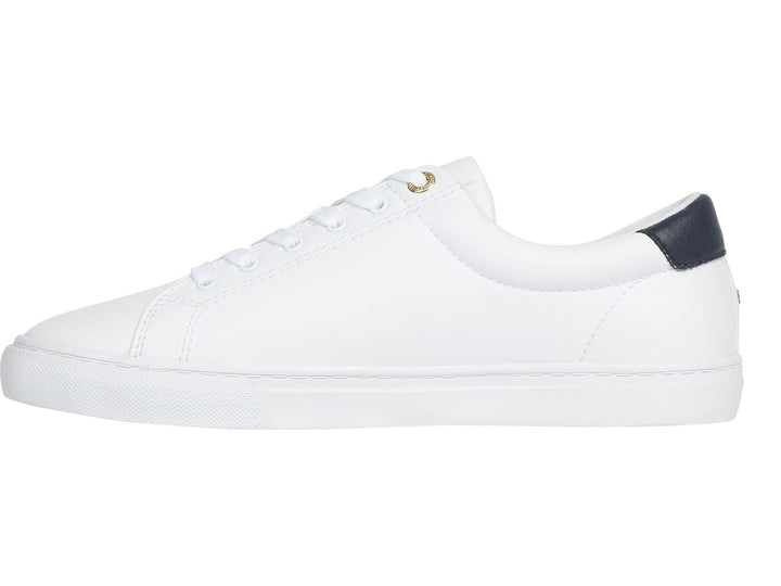 Tenis blancos de mujer marca Tommy Hilfiger con estampado de escudo en el lateral y detalle azul marino en el talón.