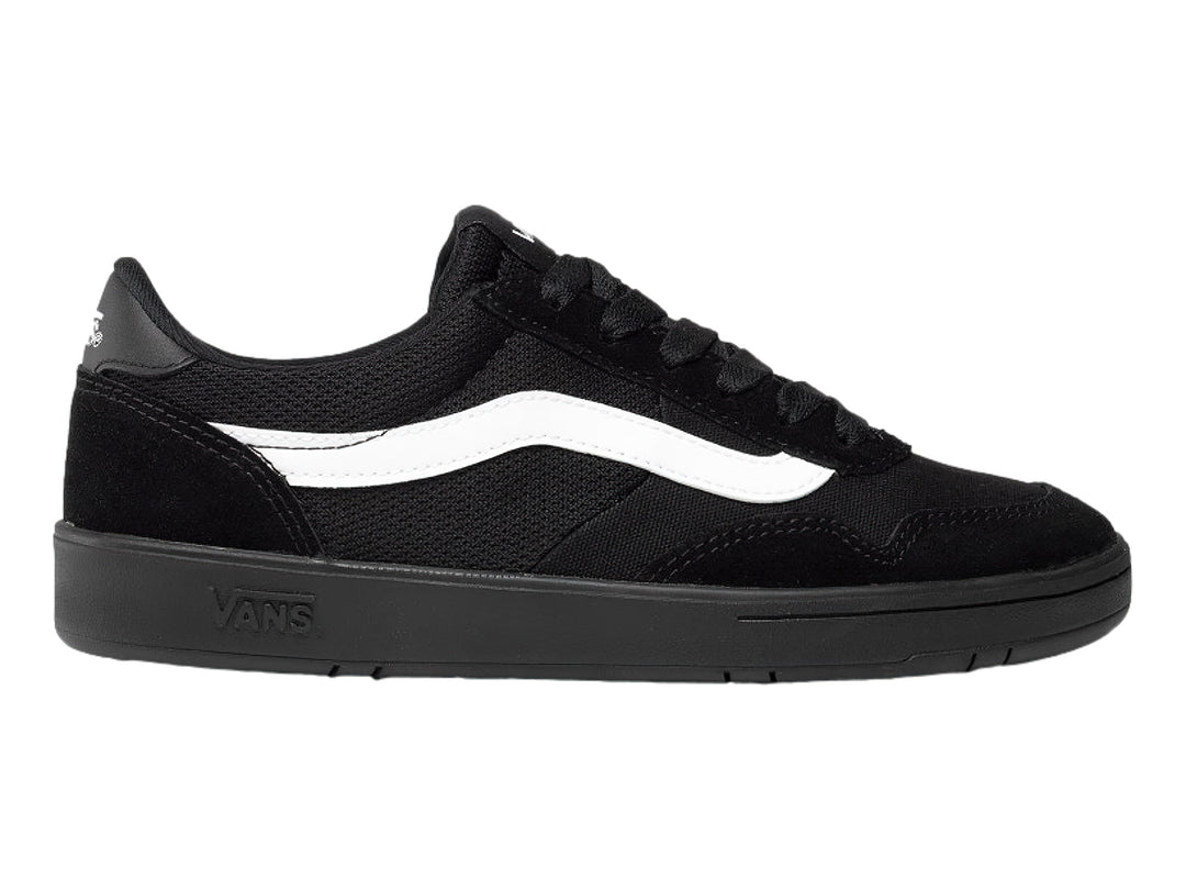 Tenis Vans color negro con franja blanca lateral y suela plana.