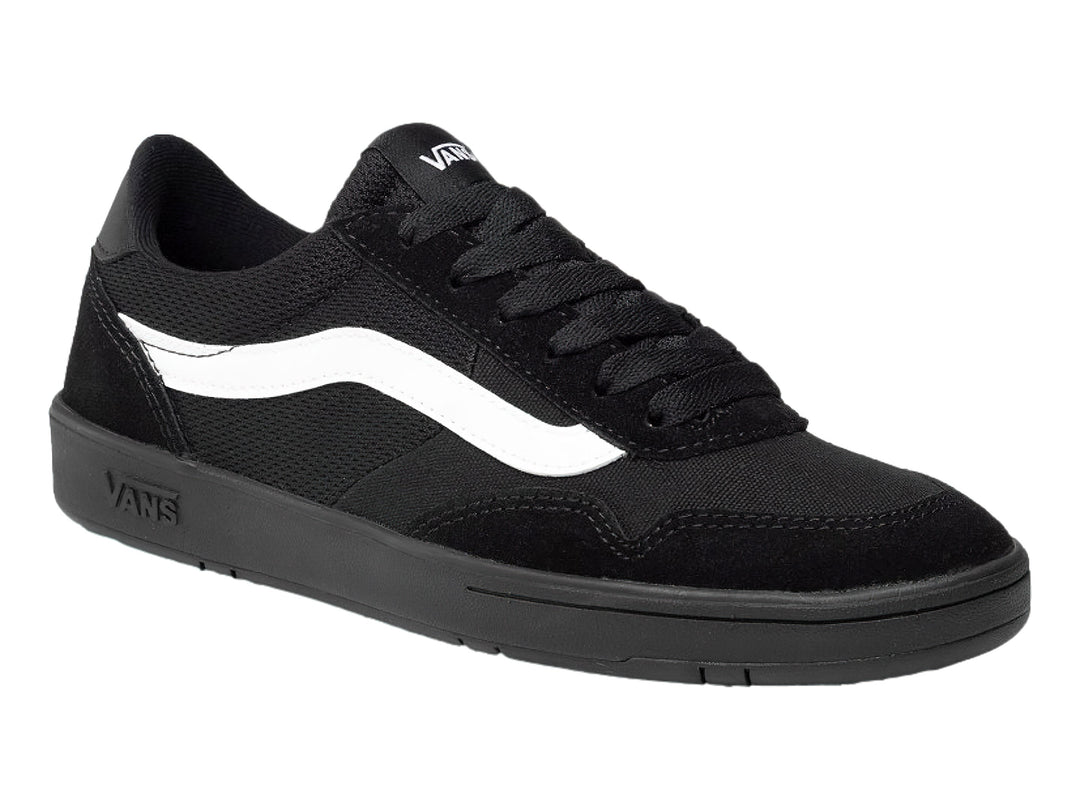 Tenis Vans color negro con franja blanca lateral y suela plana.