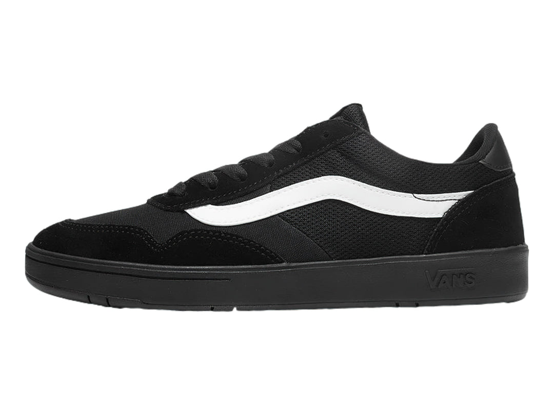 Tenis Vans color negro con franja blanca lateral y suela plana.