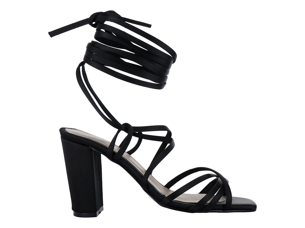 Sandalia de tacón alto color negro con tiras largas envolventes y punta cuadrada.