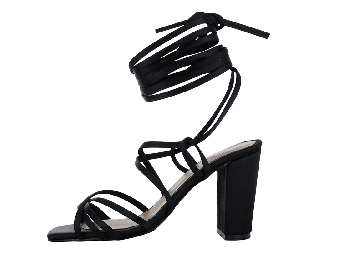 Sandalia de tacón alto color negro con tiras largas envolventes y punta cuadrada.