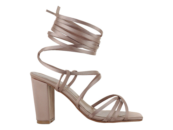 Sandalias color nutty con tacón grueso y tiras largas para amarrar alrededor de la pierna.