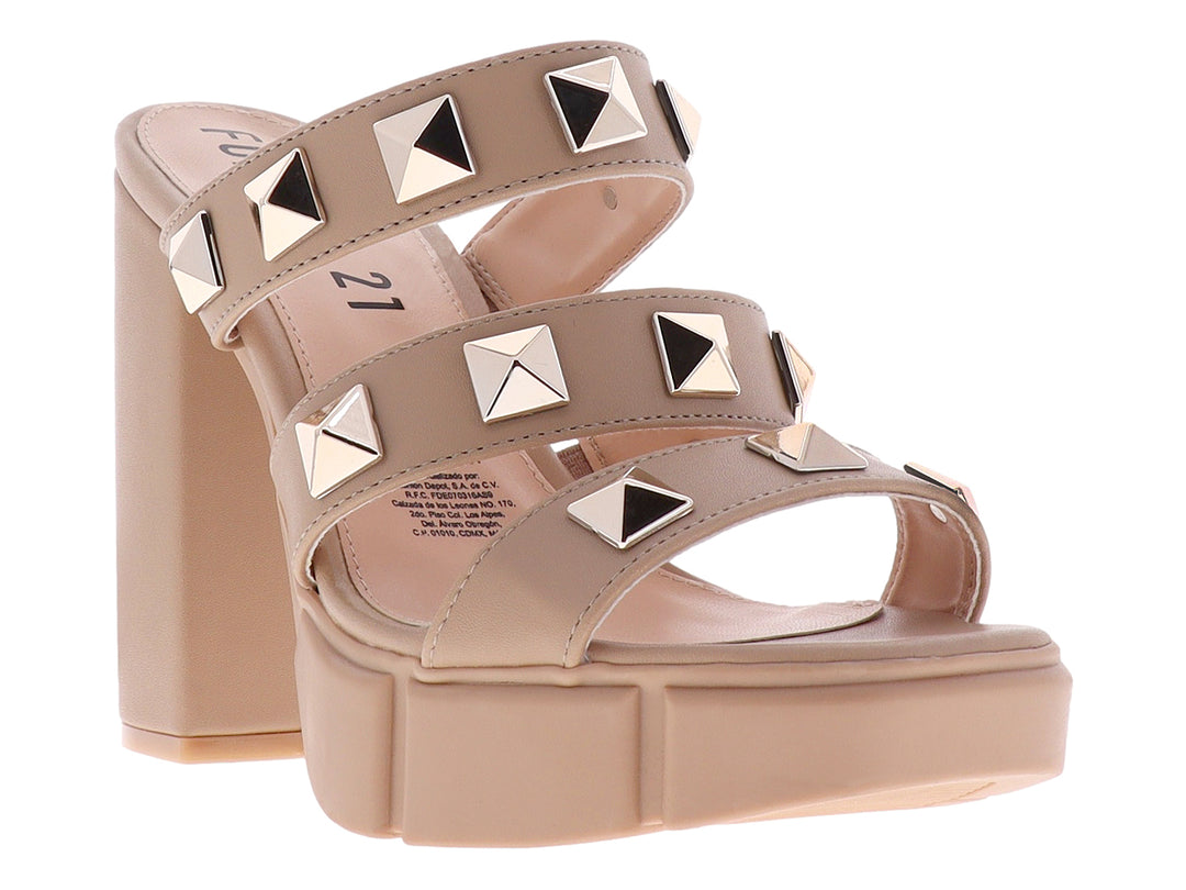 Sandalias beige de plataforma y tacón grueso con correas adornadas con tachuelas doradas cuadradas.