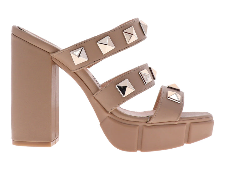 Sandalias beige de plataforma y tacón grueso con correas adornadas con tachuelas doradas cuadradas.
