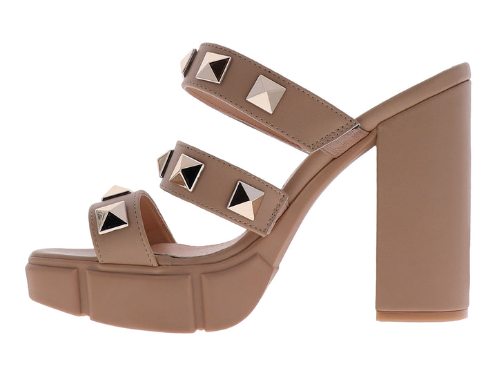 Sandalias beige de plataforma y tacón grueso con correas adornadas con tachuelas doradas cuadradas.