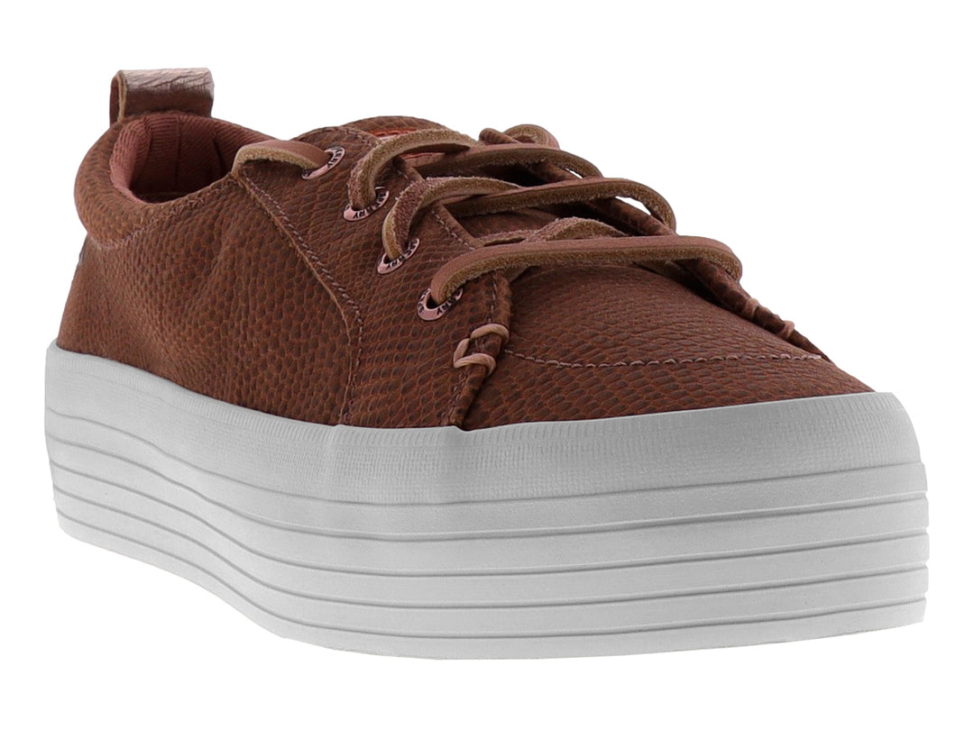 Tenis color rosa con textura de piel de serpiente y suela blanca de plataforma.