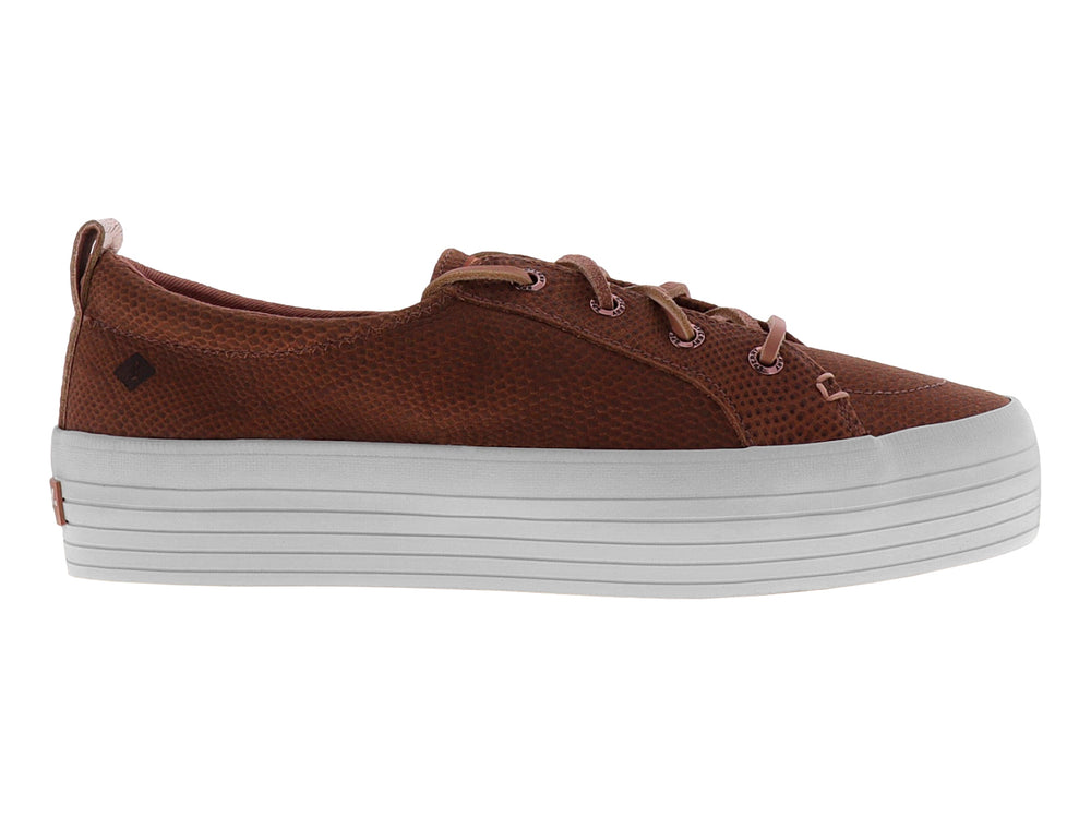 Tenis color rosa con textura de piel de serpiente y suela blanca de plataforma.