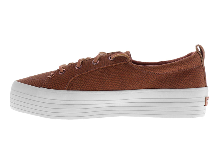 Tenis color rosa con textura de piel de serpiente y suela blanca de plataforma.