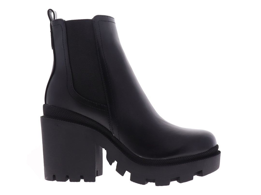 Bota negra de tobillo con tacón grueso y suela de plataforma dentada.