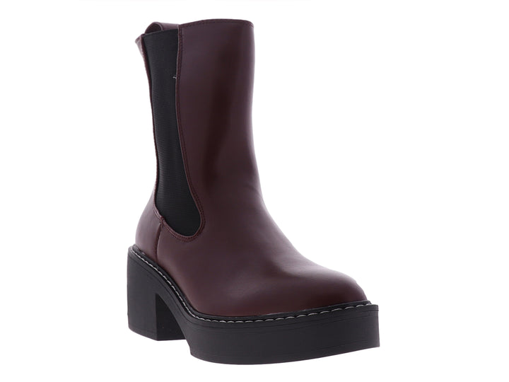 Botín Chelsea Nine West color vino con suela de plataforma negra y costuras blancas.