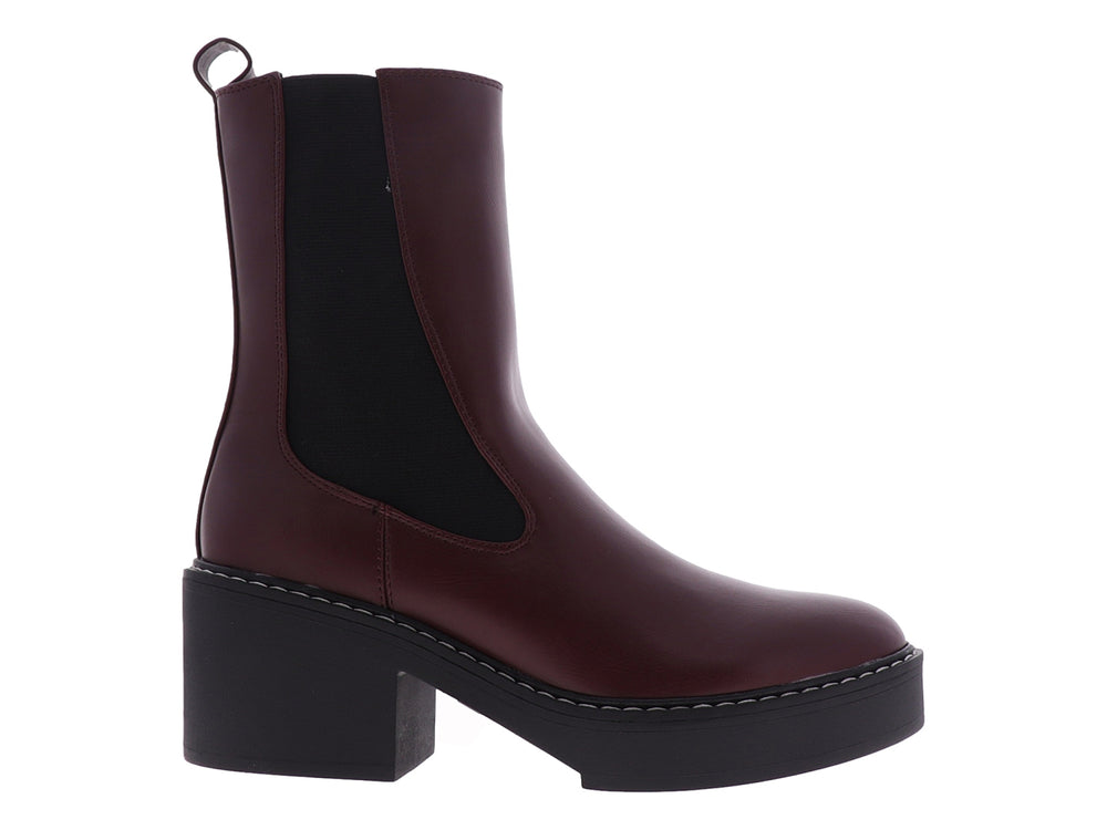 Botín Chelsea Nine West color vino con suela de plataforma negra y costuras blancas.