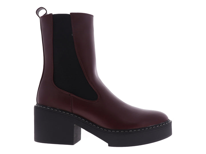 Botín Chelsea Nine West color vino con suela de plataforma negra y costuras blancas.