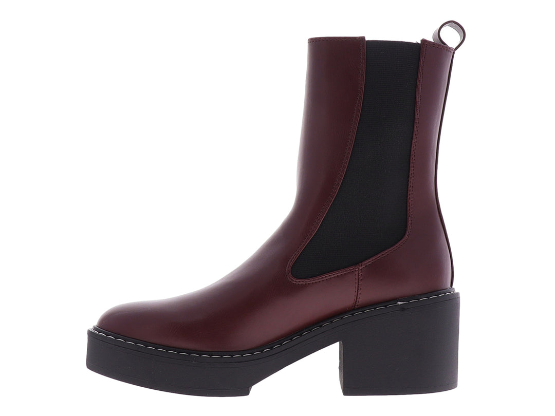 Botín Chelsea Nine West color vino con suela de plataforma negra y costuras blancas.