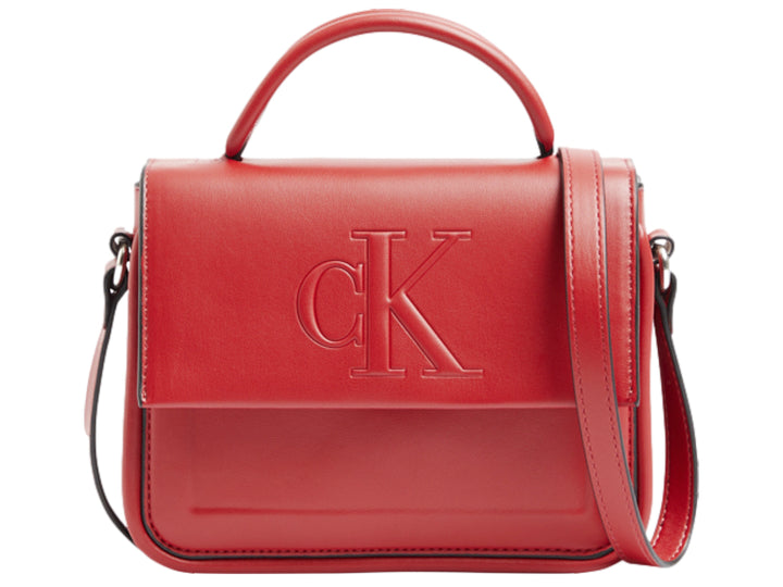 Bolso rojo de Calvin Klein con asa superior, correa ajustable y logo CK grabado en relieve.