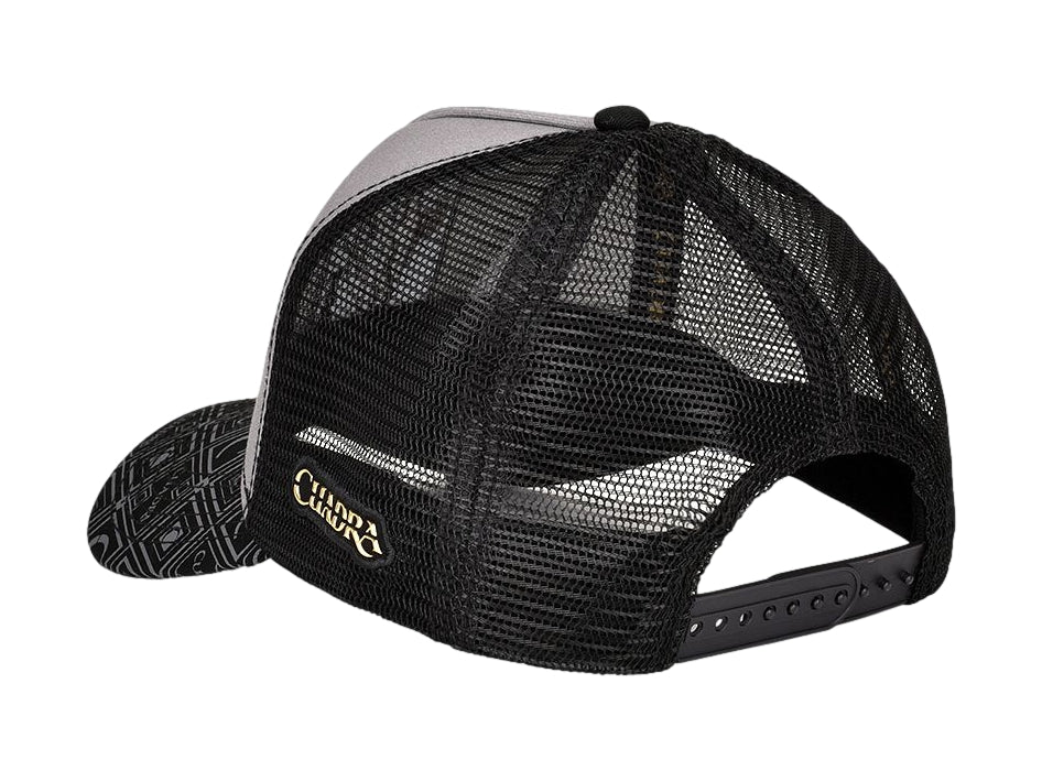 Gorra Cuadra en colores negro y gris con un parche frontal de un elefante y visera con estampado geométrico.