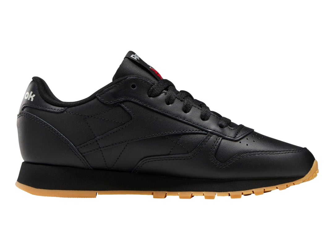 Tenis Reebok Classic Leather en color negro con suela marrón y detalles minimalistas.