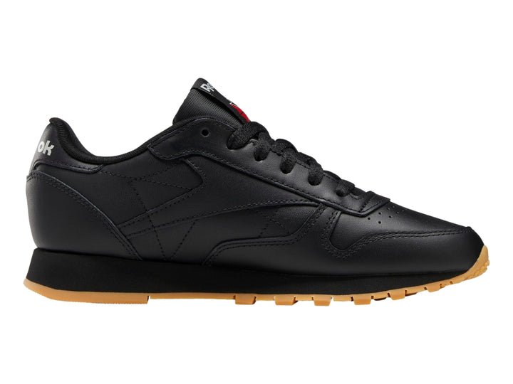 Tenis Reebok Classic Leather en color negro con suela marrón y detalles minimalistas.
