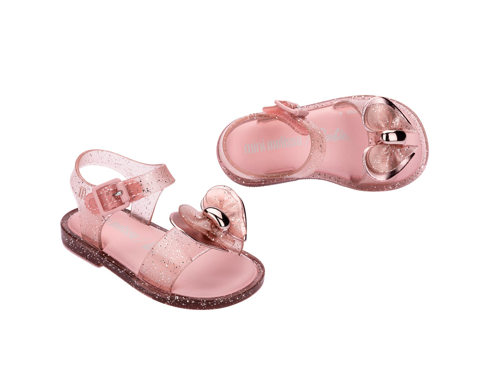 Par de sandalias Mini Melissa color rosa brillante con detalle de moño y correa ajustable para niña.